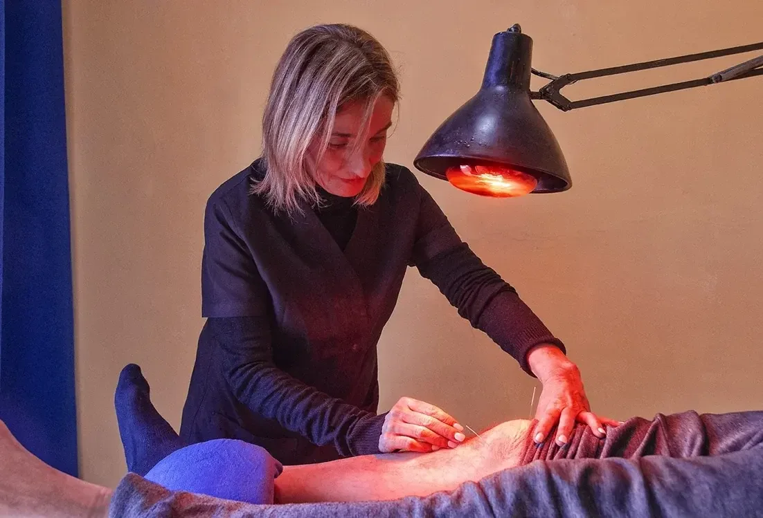 Laura atendiendo a una persona durante una sesión de acupuntura en Tossa de Mar